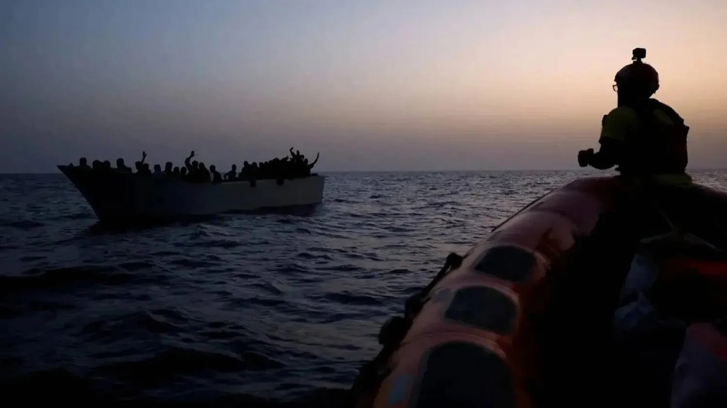 Migrants give signals to NGO Proactiva Open Arms Uno rescue boat in central Mediterranean Sea, August 17, 2022