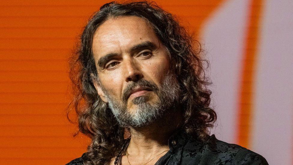 Russell Brand says he will return to the UK to contest rape, sex assault charges